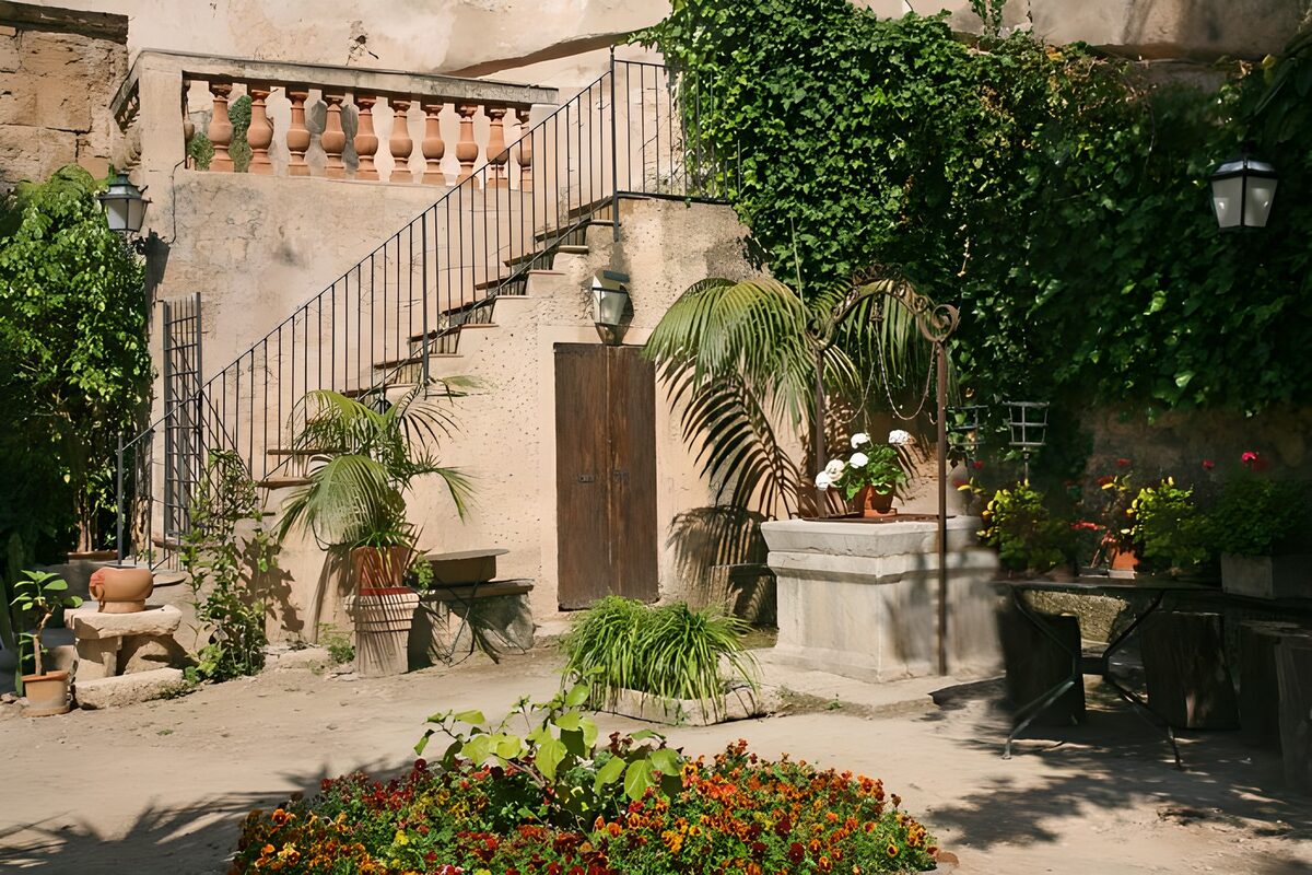 Sonniger Innenhof mit Blumen und Brunnen