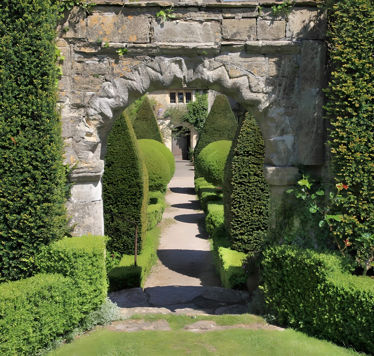 Alter Steinbogen zum sonnigen Formgarten