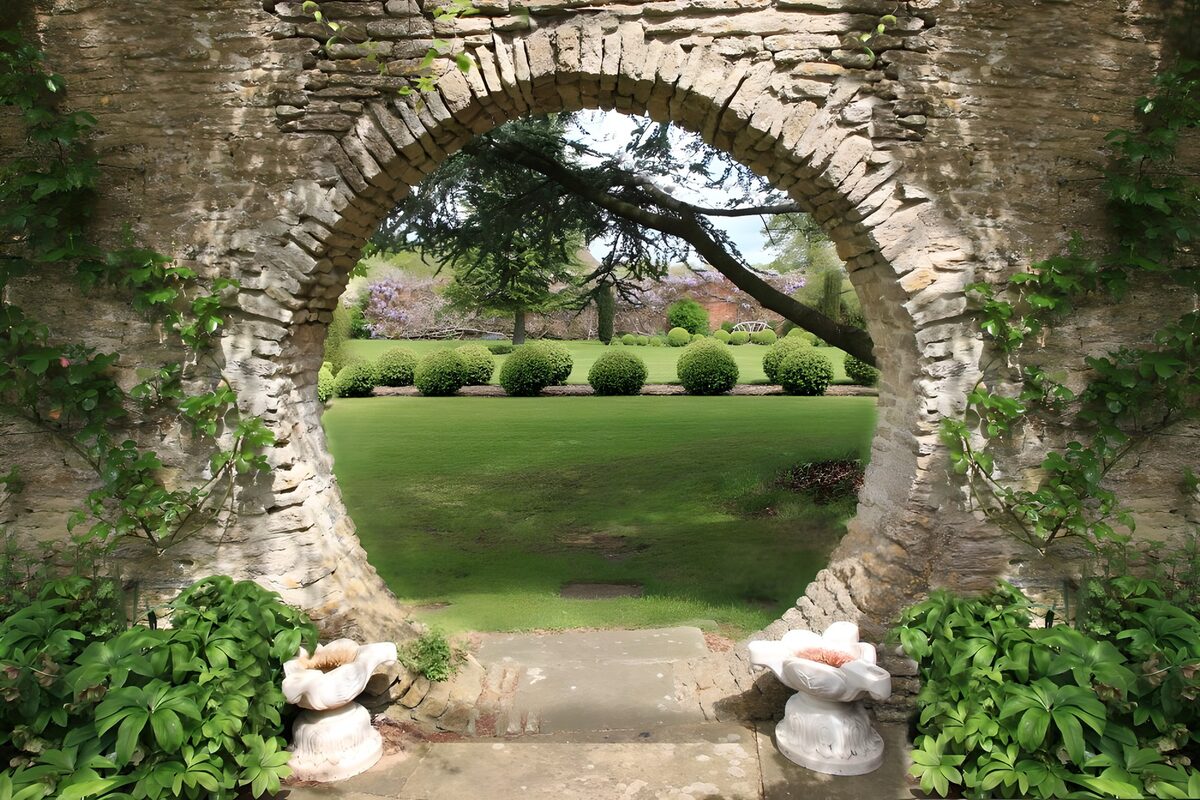 Gartenblick durch den runden Steinbogen