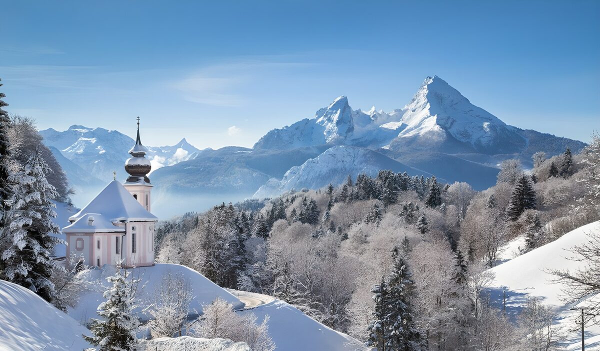 Kleine Kirche vor verschneiten Bergen