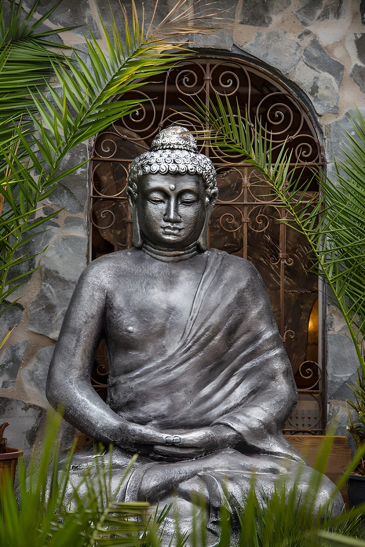 Buddha-Statue zwischen grünen Palmwedeln