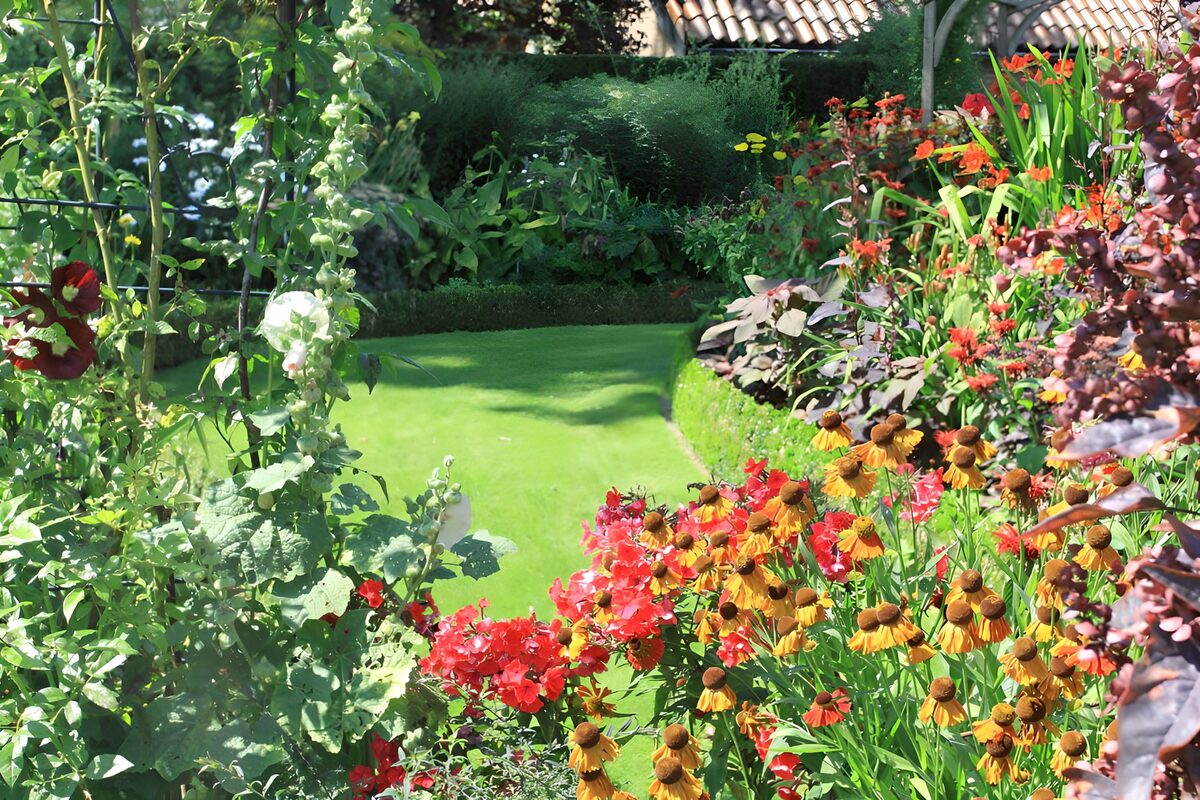 Sommergarten mit Rasen und bunten Beeten