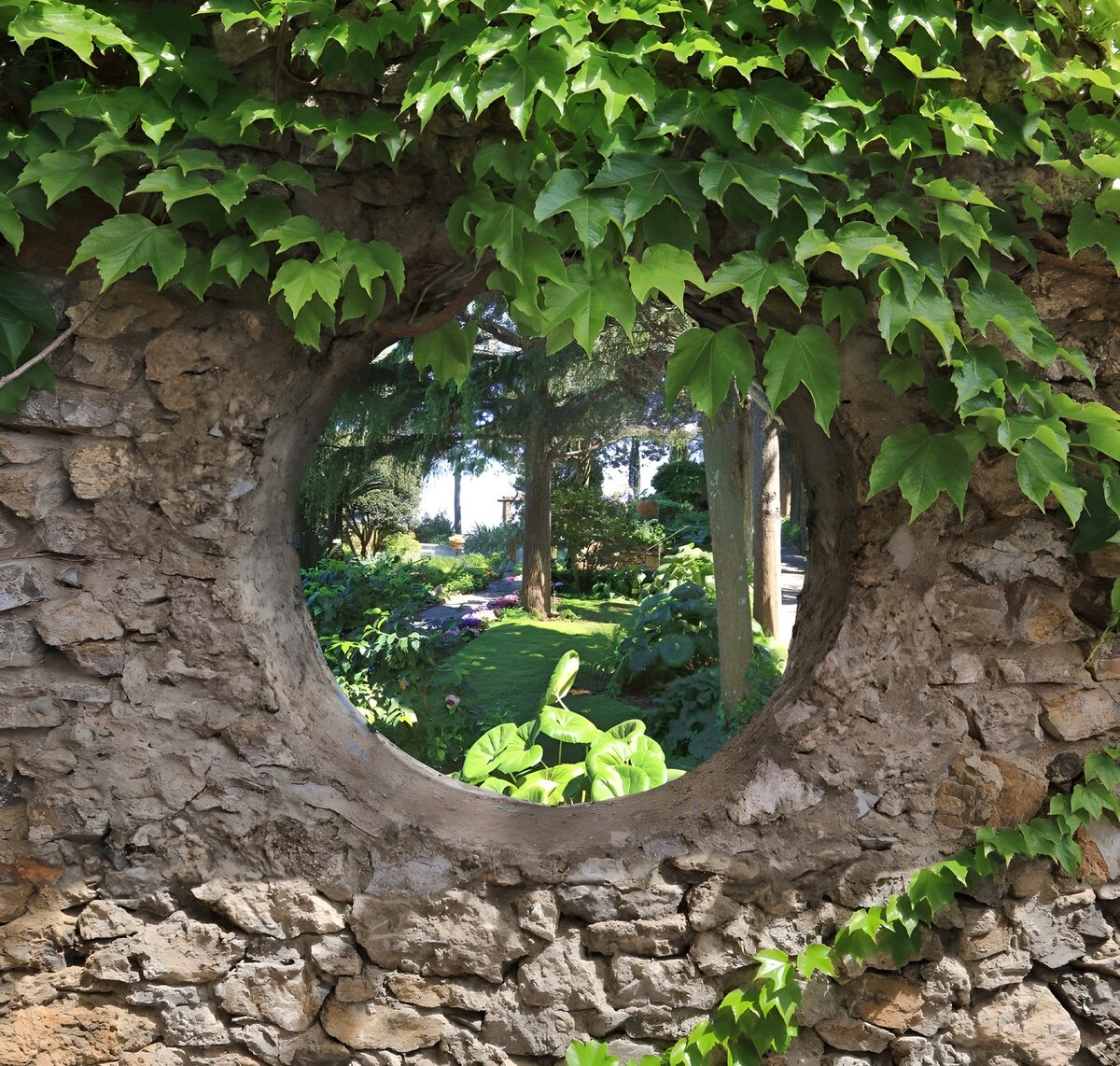 Rundes Mauerfenster mit Blick ins Grüne
