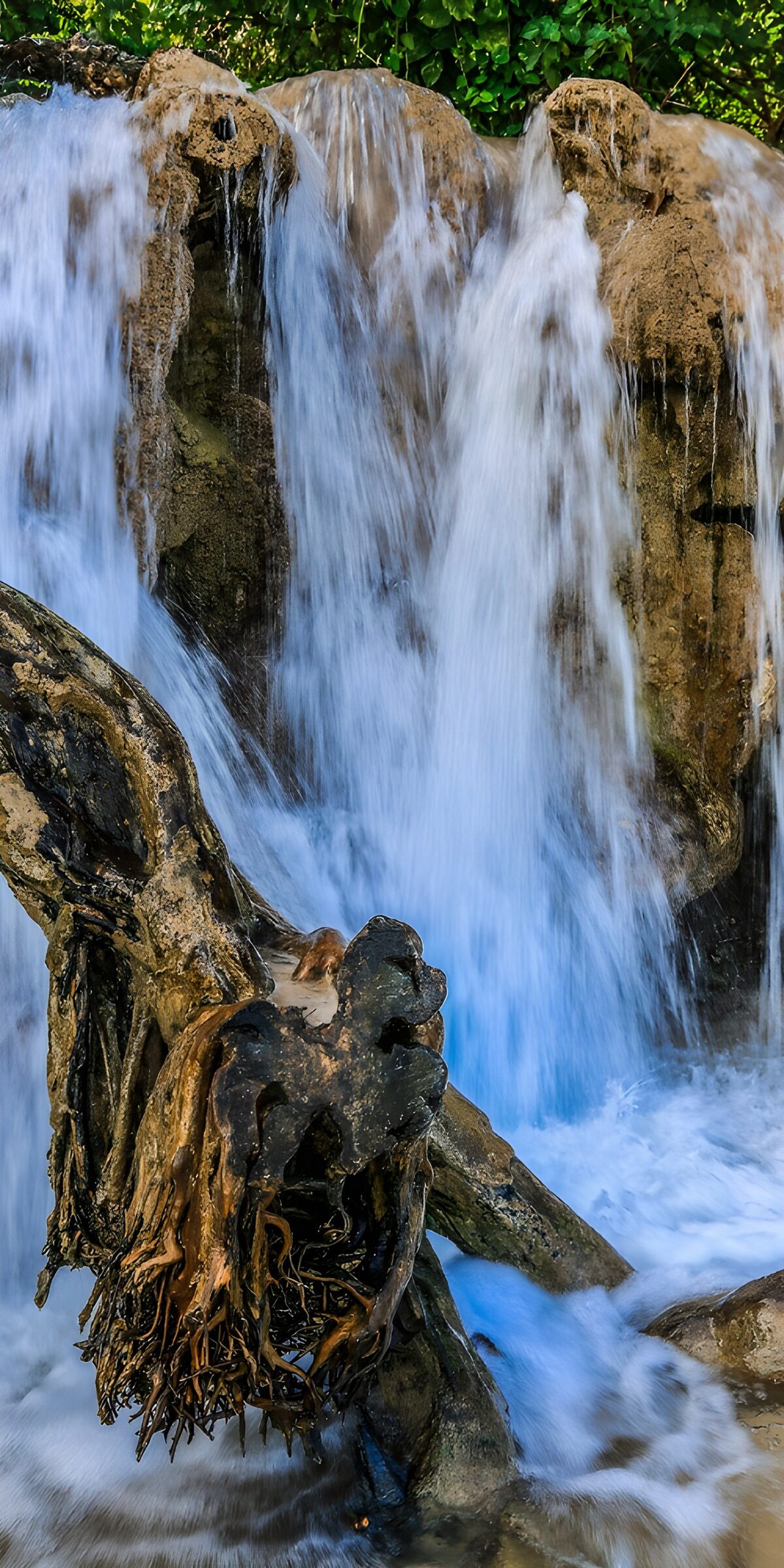 Wasserfall über Felsen und Wurzeln