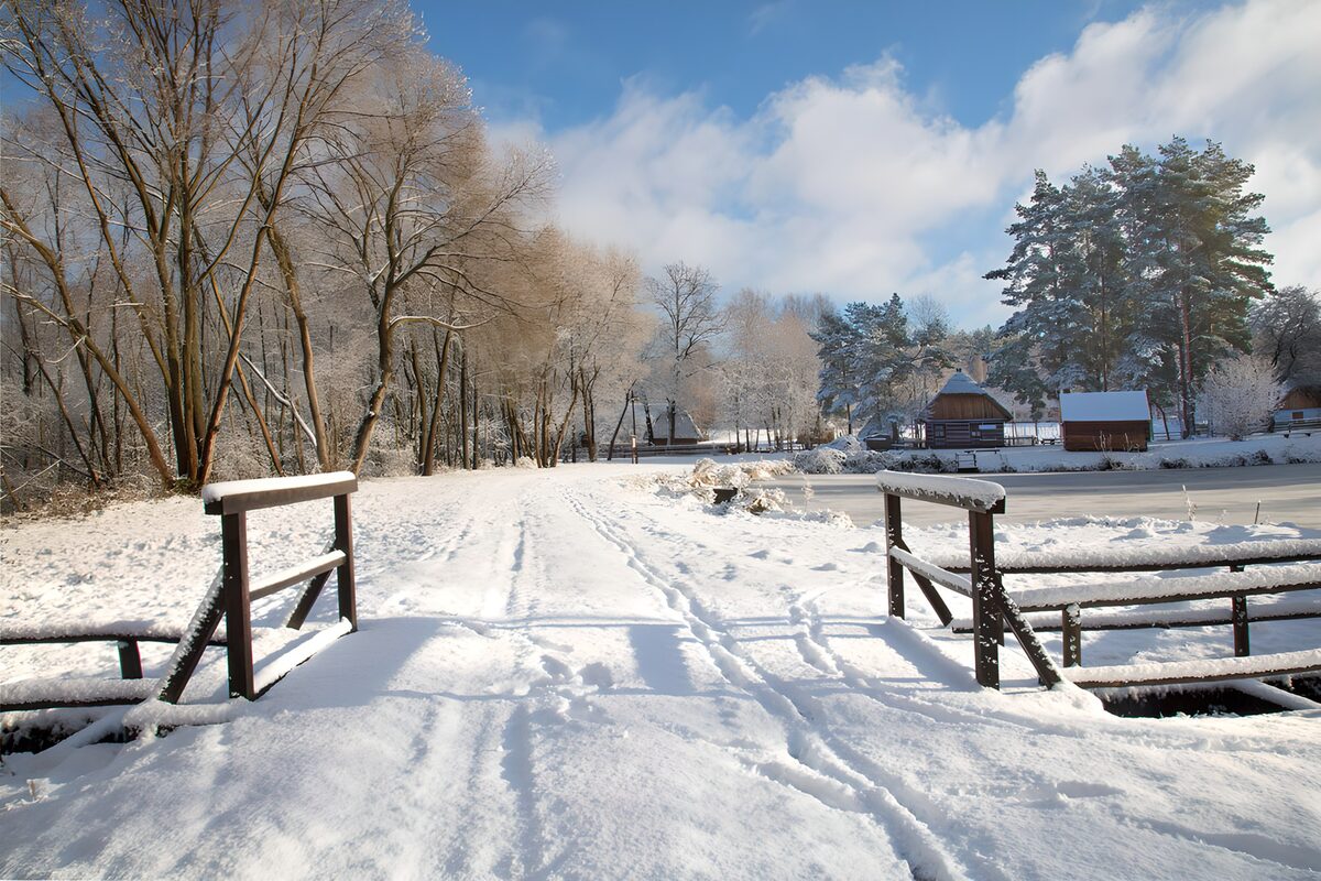 Verschneite Holzbrücke am stillen See
