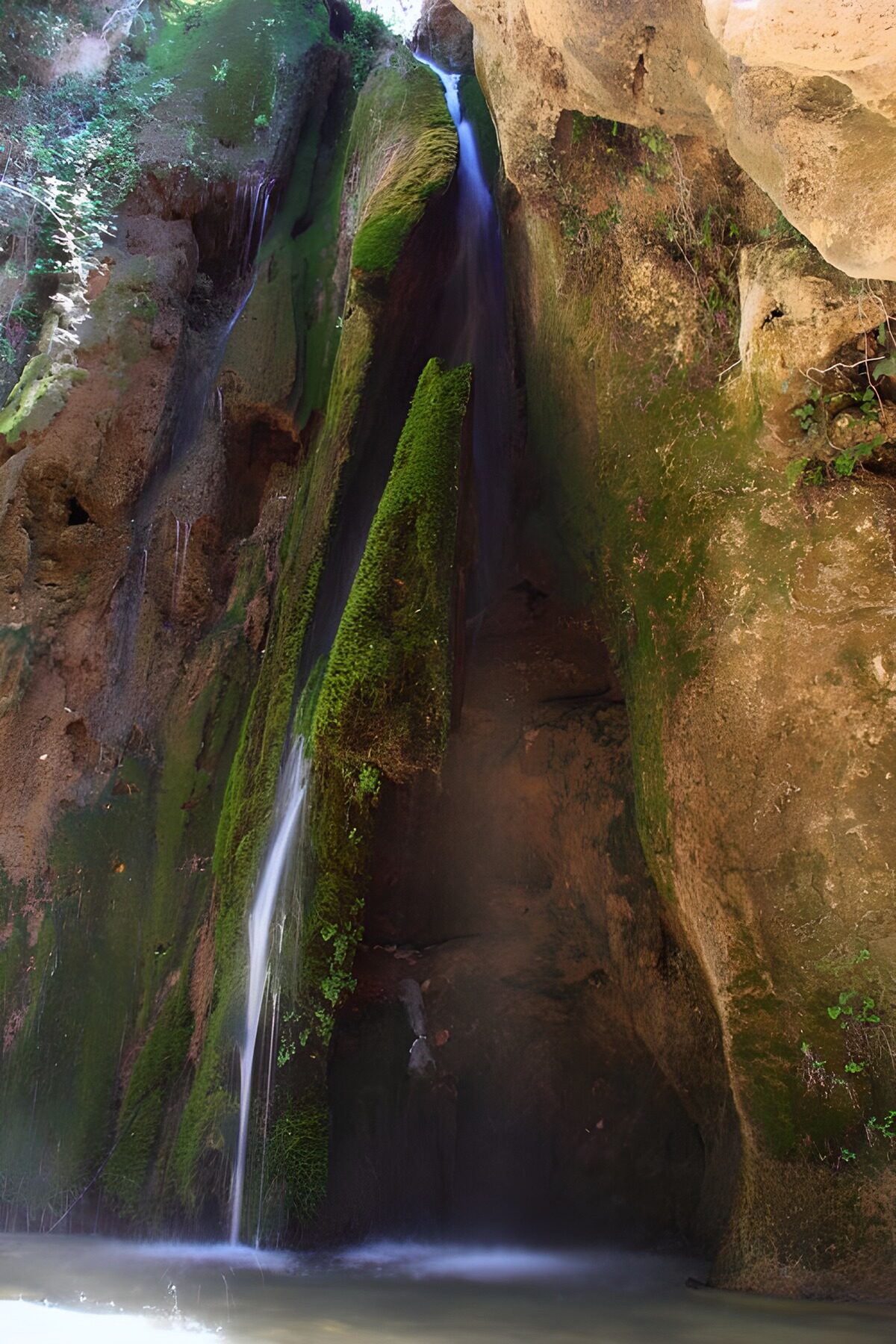 Schmaler Wasserfall im kühlen Fels