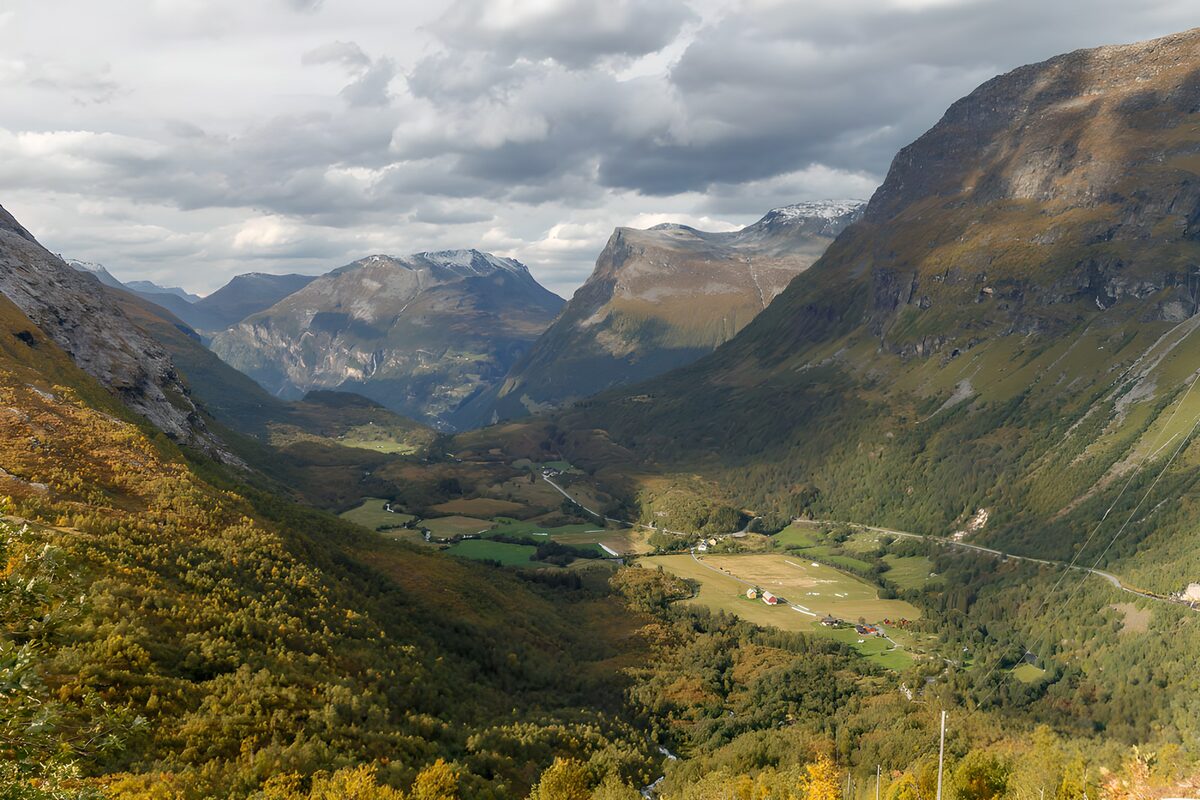 Weites Bergtal mit Wiesen und Wolkenschatten