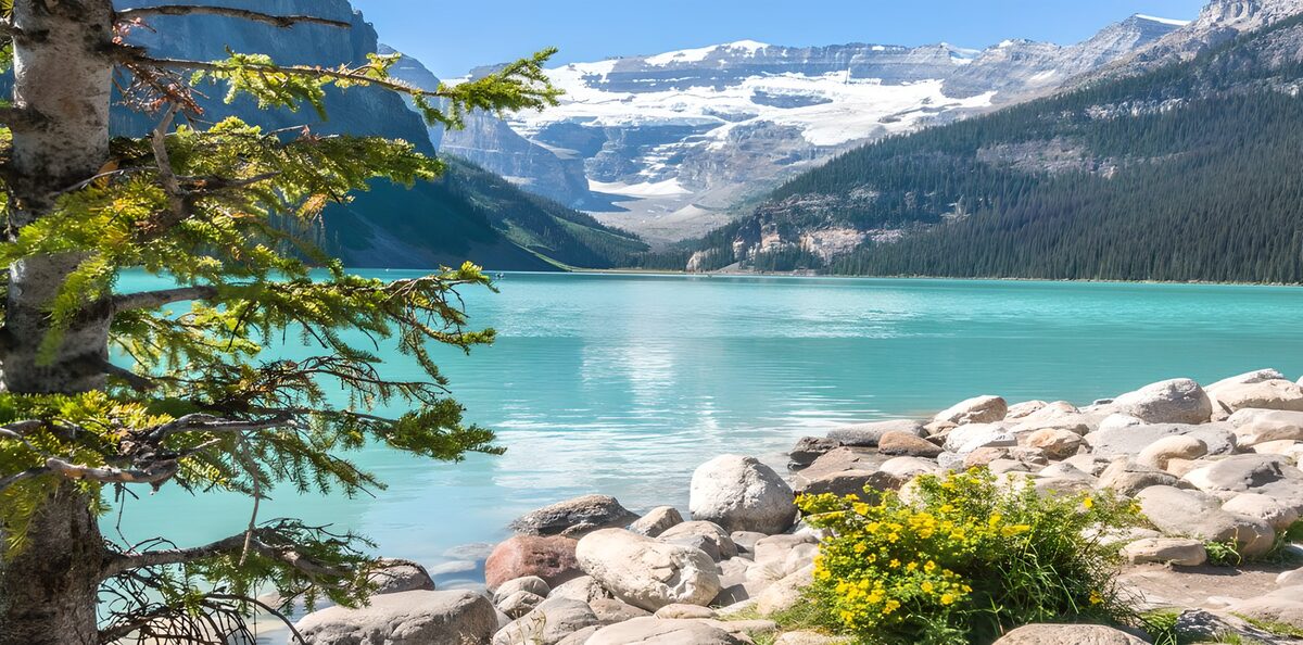 Türkiser Bergsee vor verschneiten Gipfeln