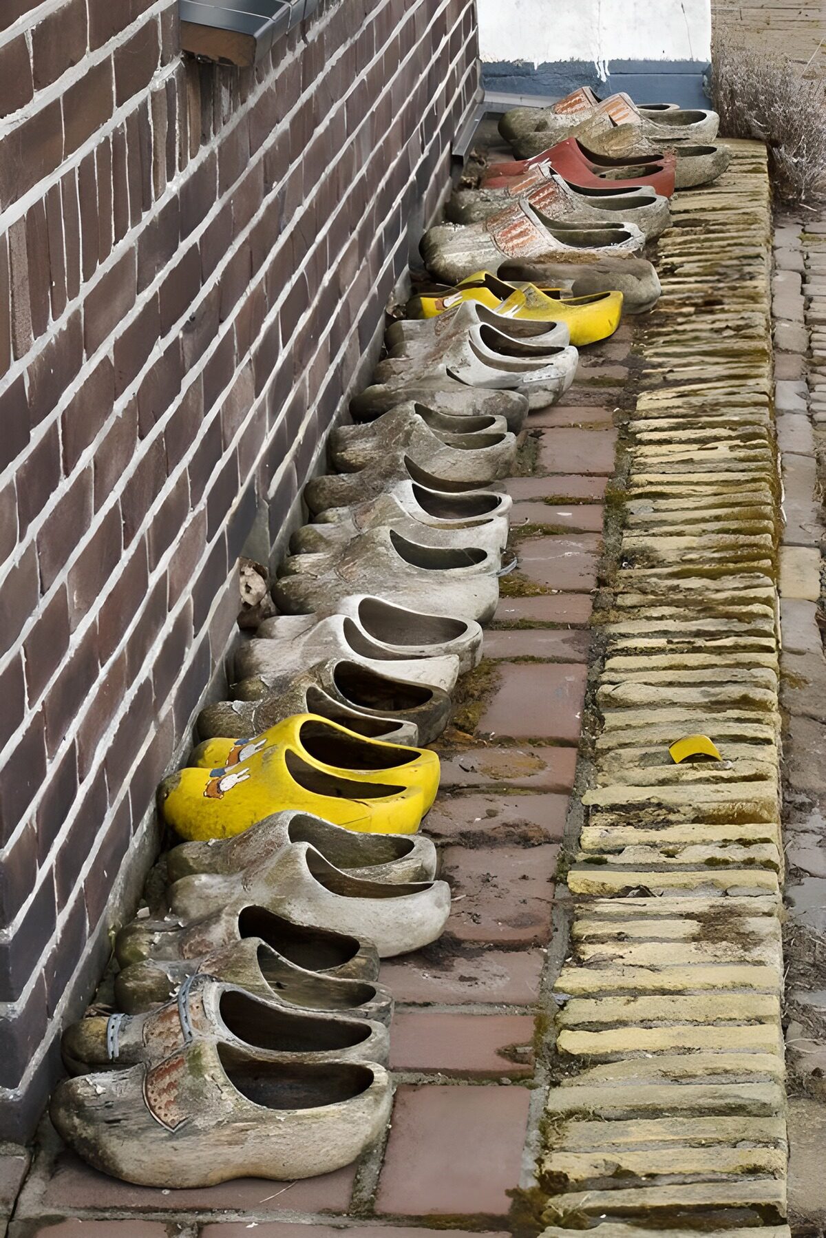 Verwitterte Holzschuhe in Reih und Glied