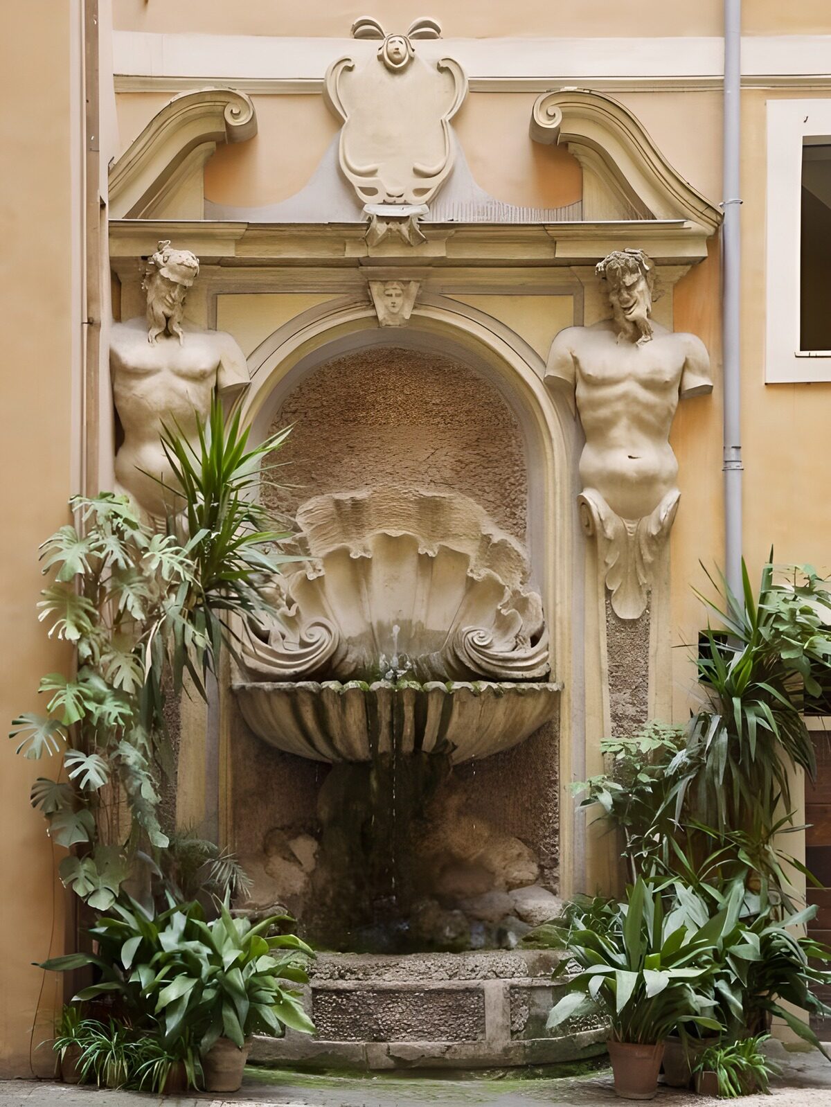 Steinbrunnen mit Figuren und üppigem Grün