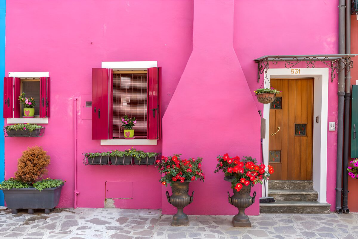 Pinke Hausfassade mit Blumengruß