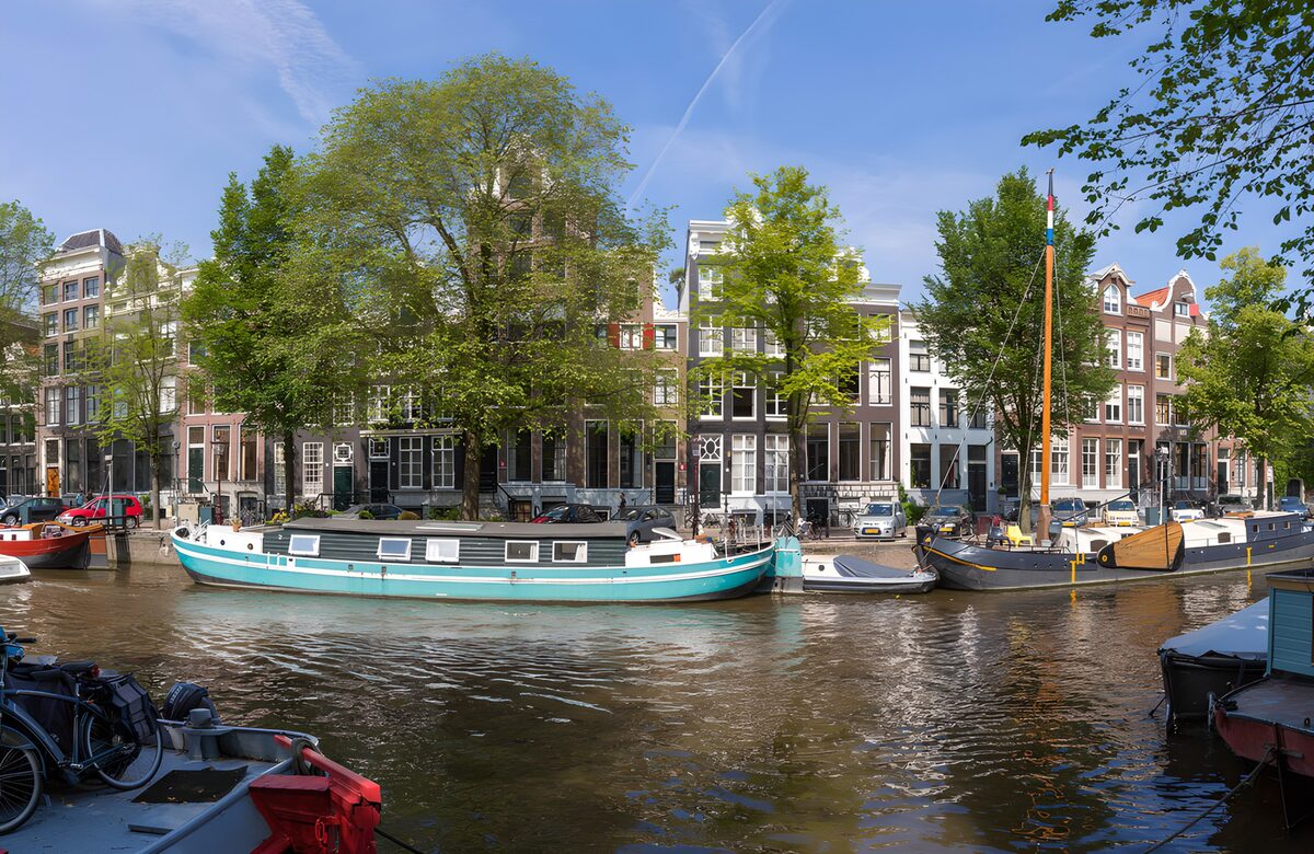 Hausboote und grüne Bäume an der Gracht