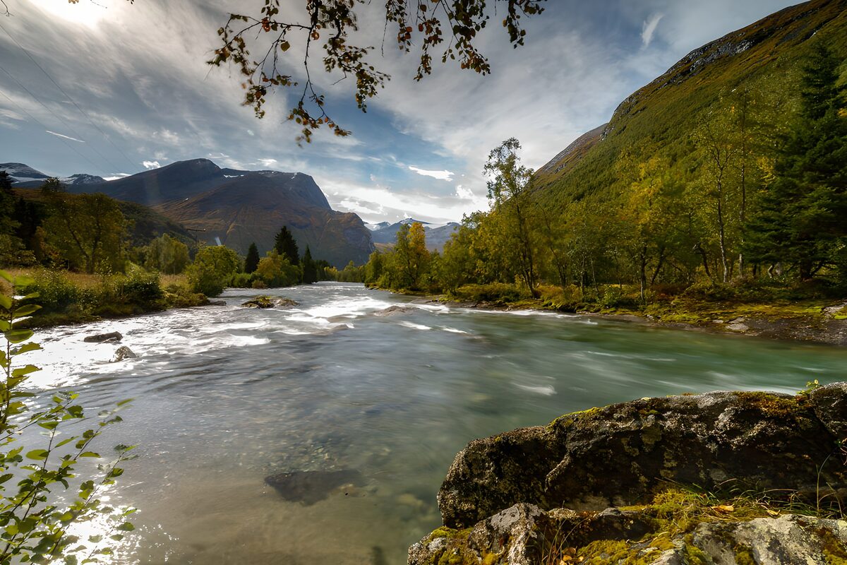 Türkiser Fluss im herbstlichen Bergtal