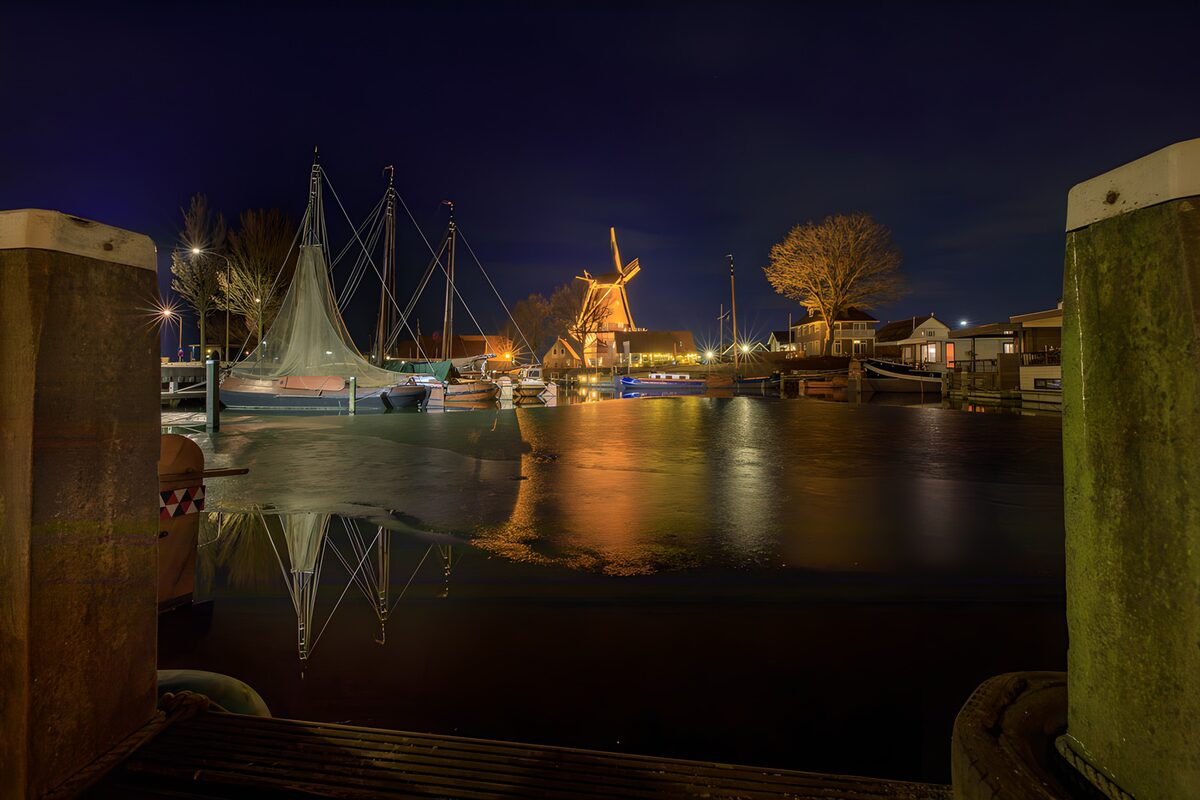 Segelboote und Windmühle im Nachtlicht