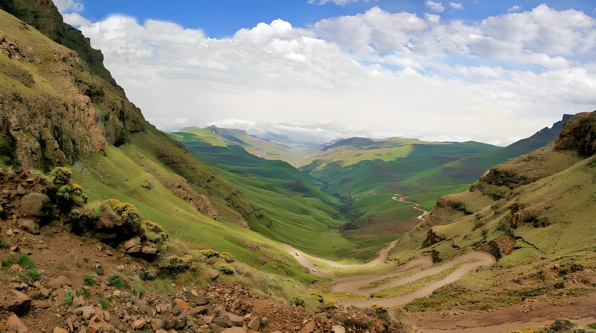 Weites Bergtal mit kurvigem Schotterweg