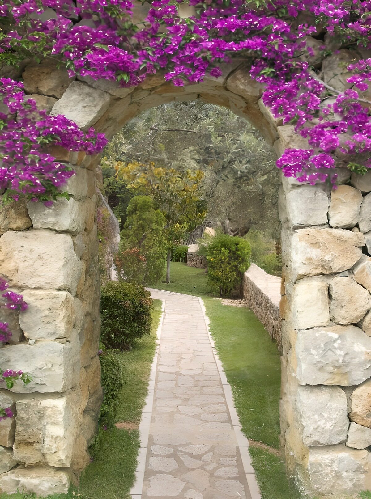 Steinbogen mit Blüten und Gartenblick