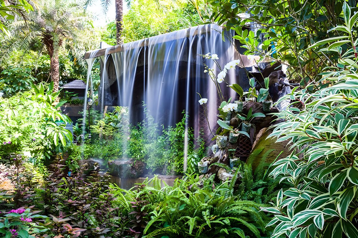 Breiter Wasserfall im üppigen Tropengarten