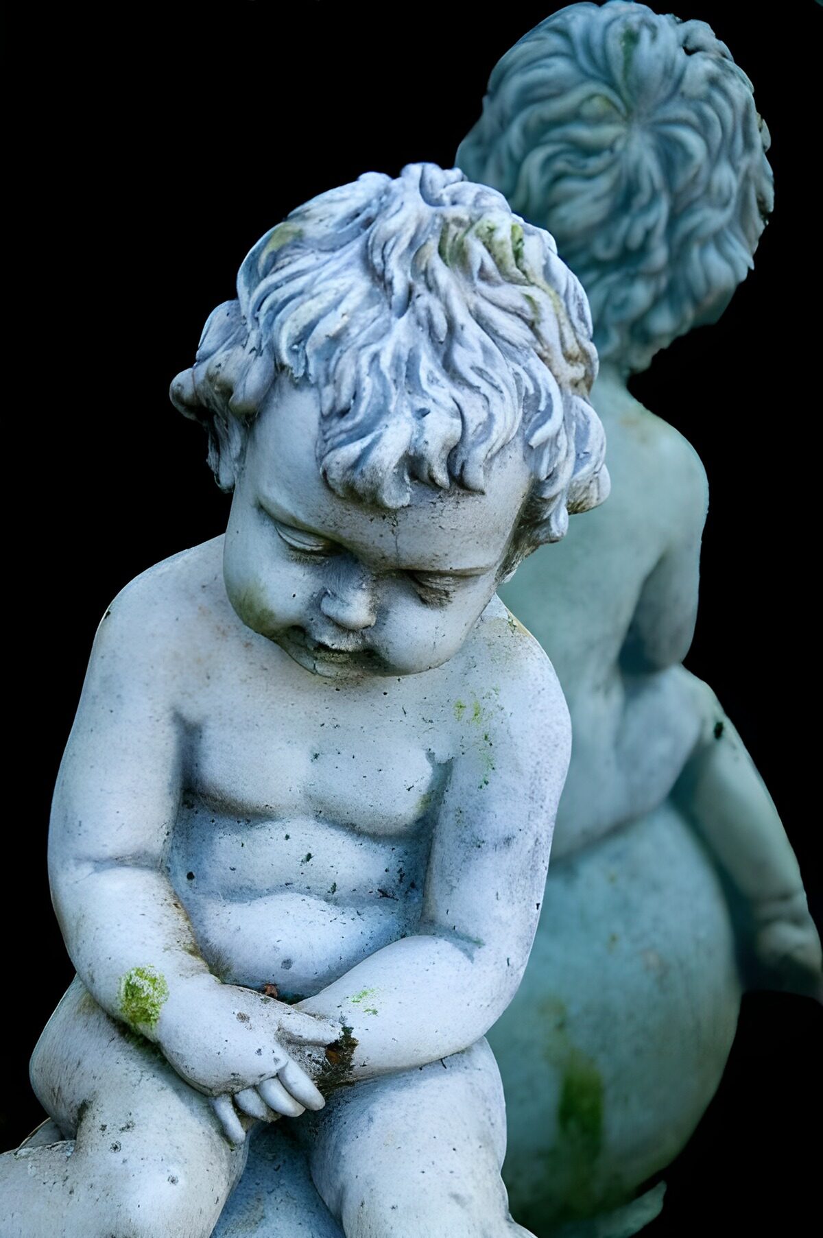 Zwei Kinderfiguren aus verwittertem Stein