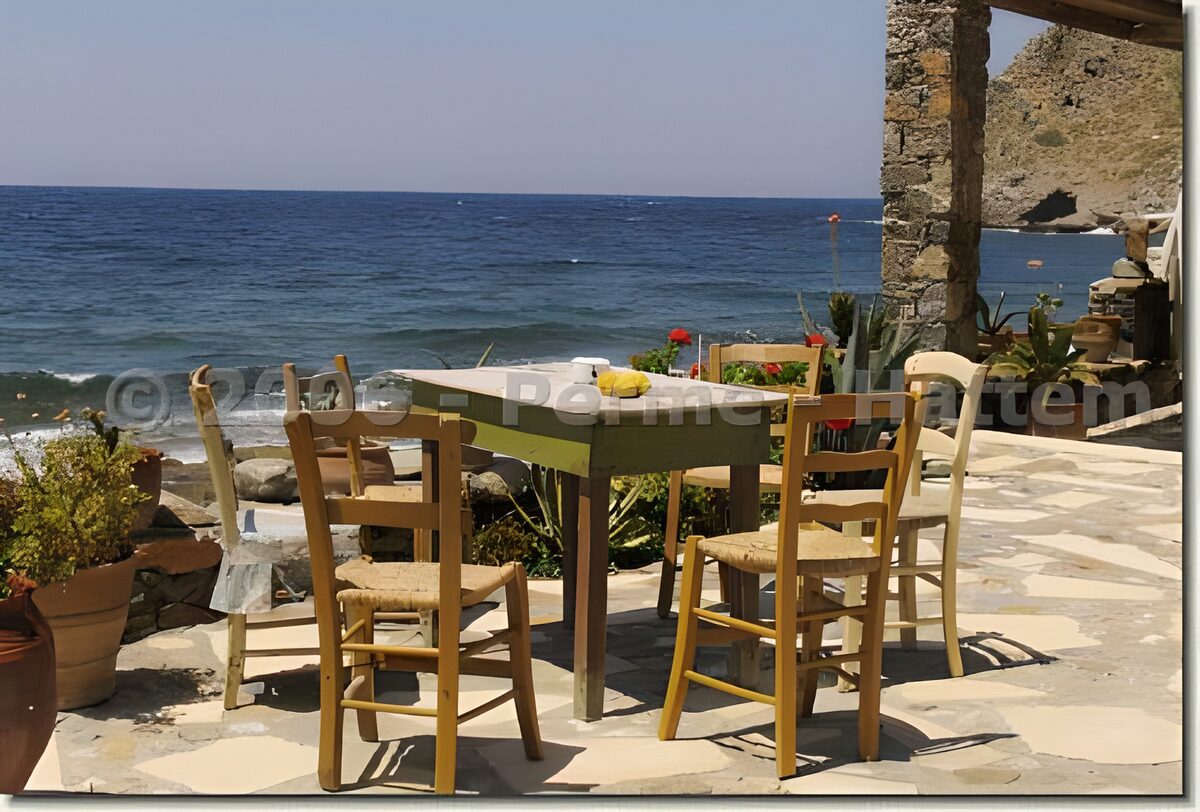 Sonnenterrasse mit grünem Tisch am Meer