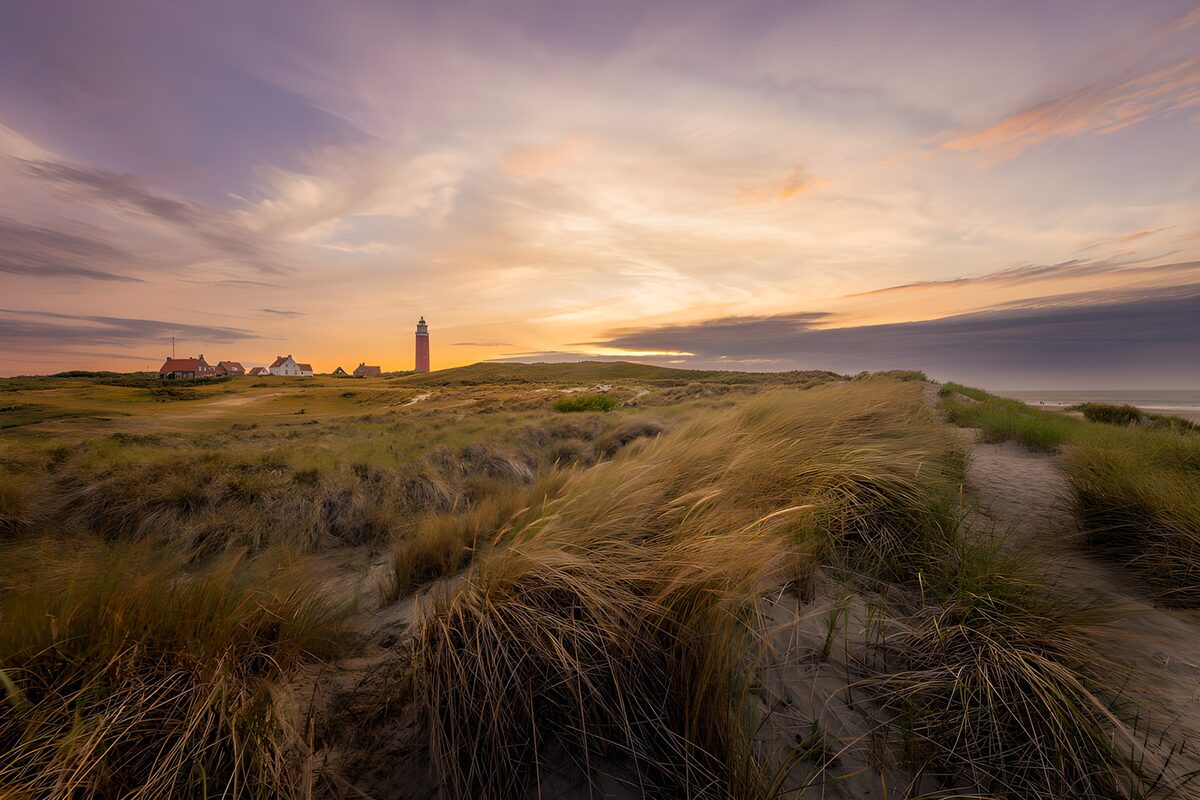 Dünen und Leuchtturm im Abendlicht