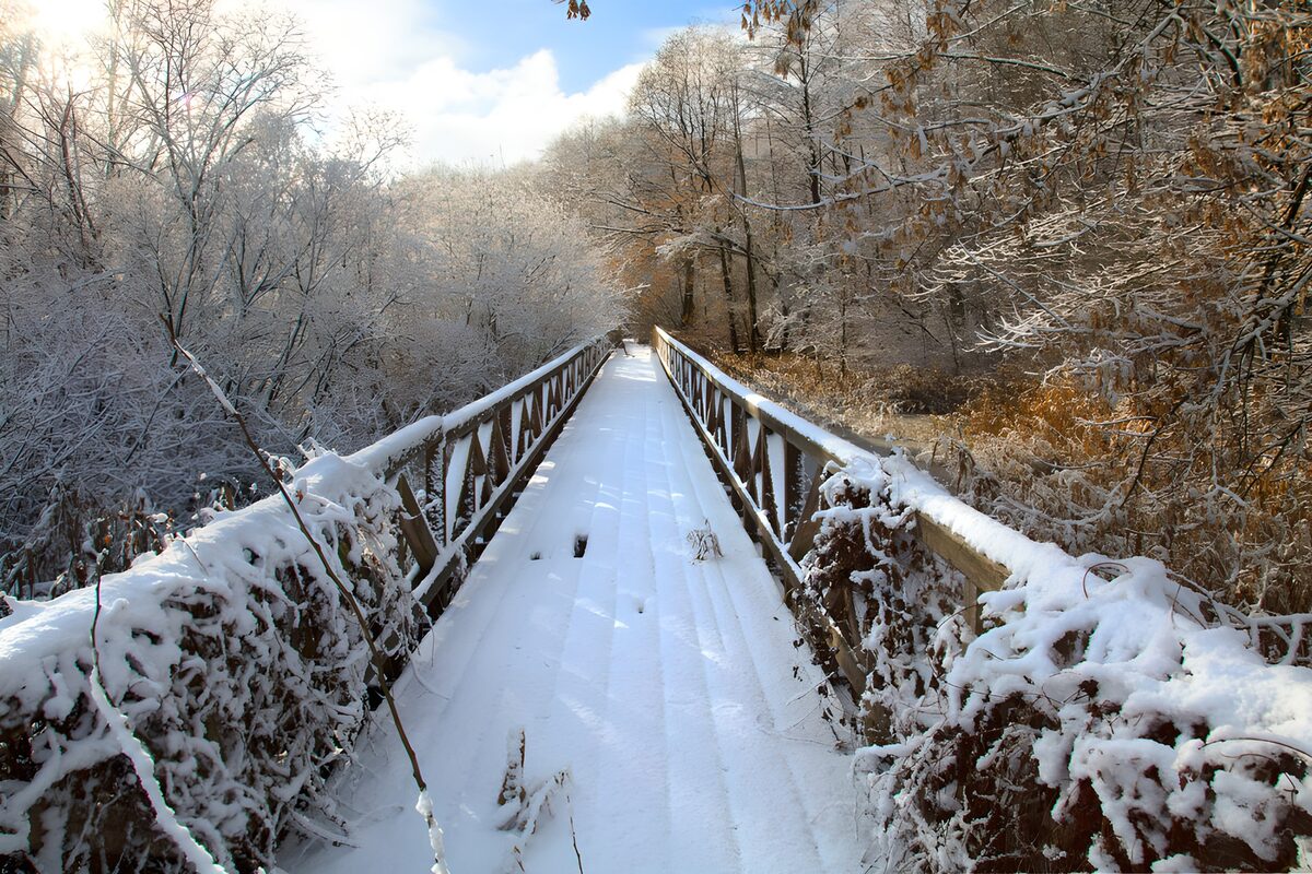 Verschneite Holzbrücke im stillen Wald