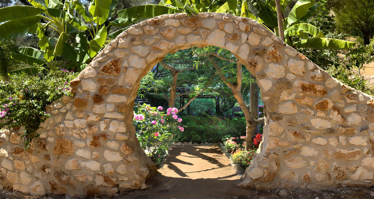Sonniger Steinbogen zum grünen Garten