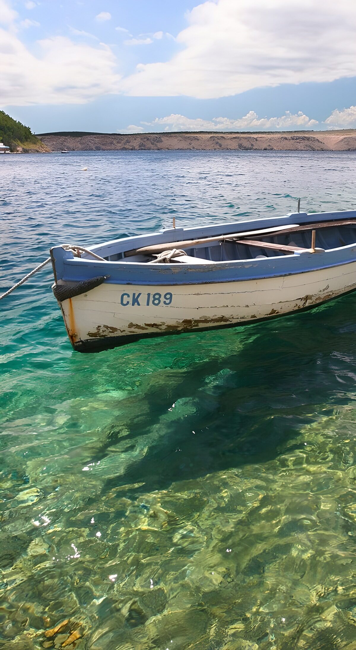 Altes Ruderboot auf klarem Küstenwasser