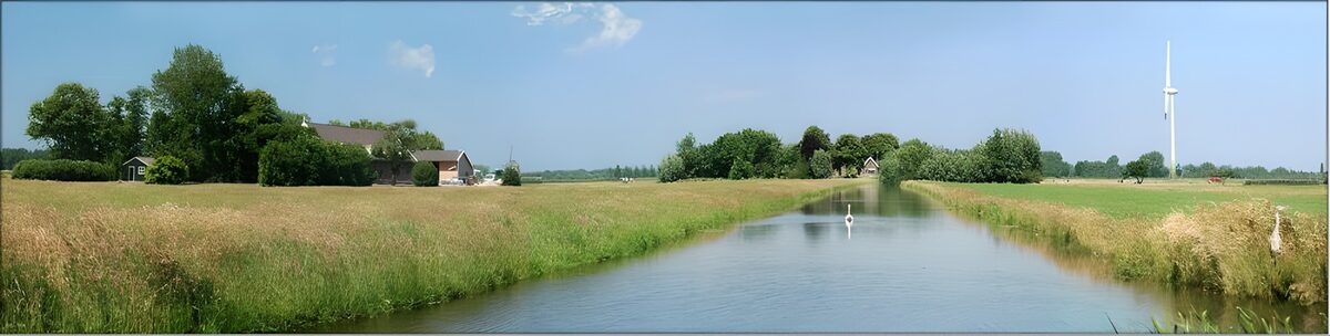 Wiesenkanal mit Windrad im Sommer