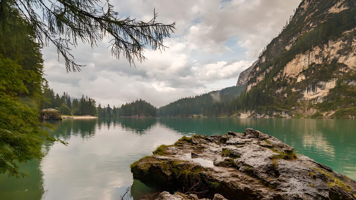 Grüner Bergsee vor steiler Felswand