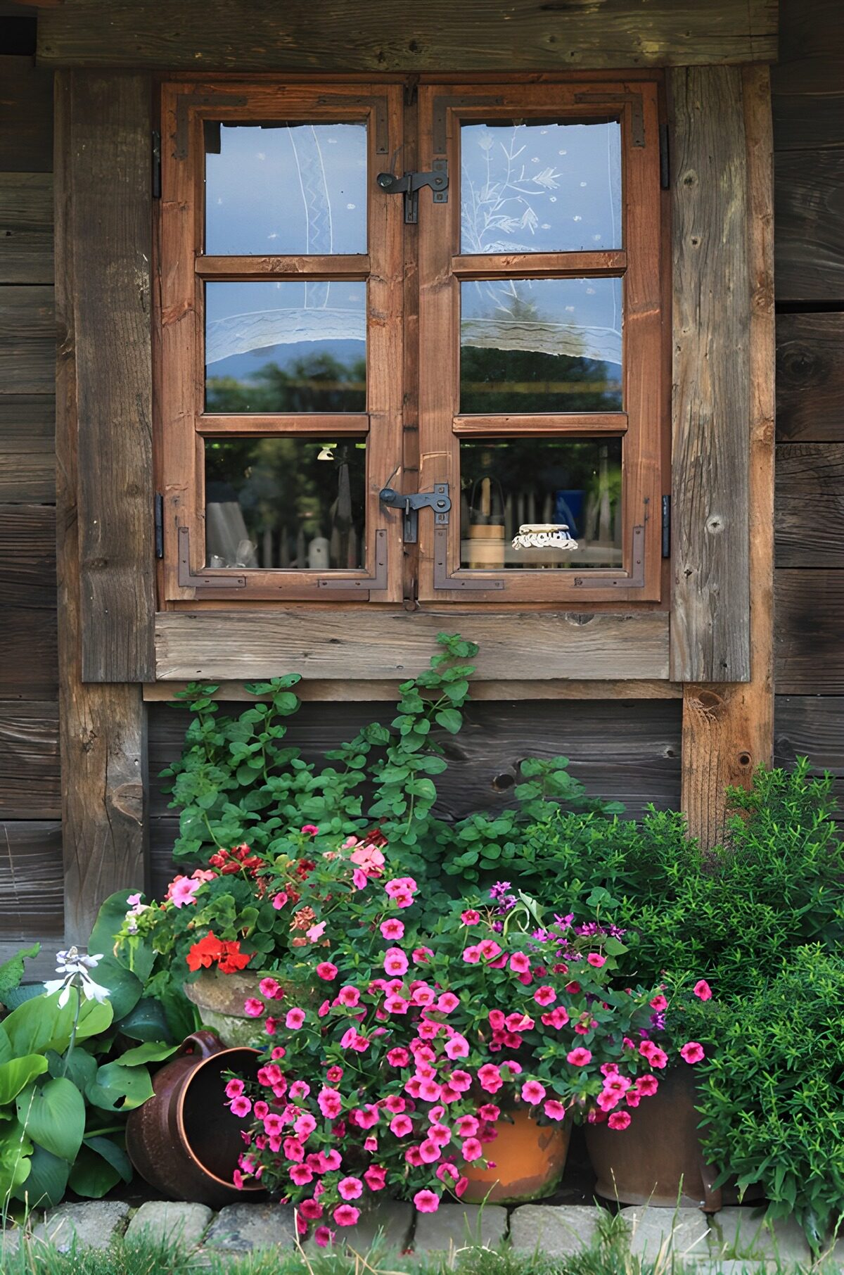 Rustikales Holzfenster mit rosa Blüten