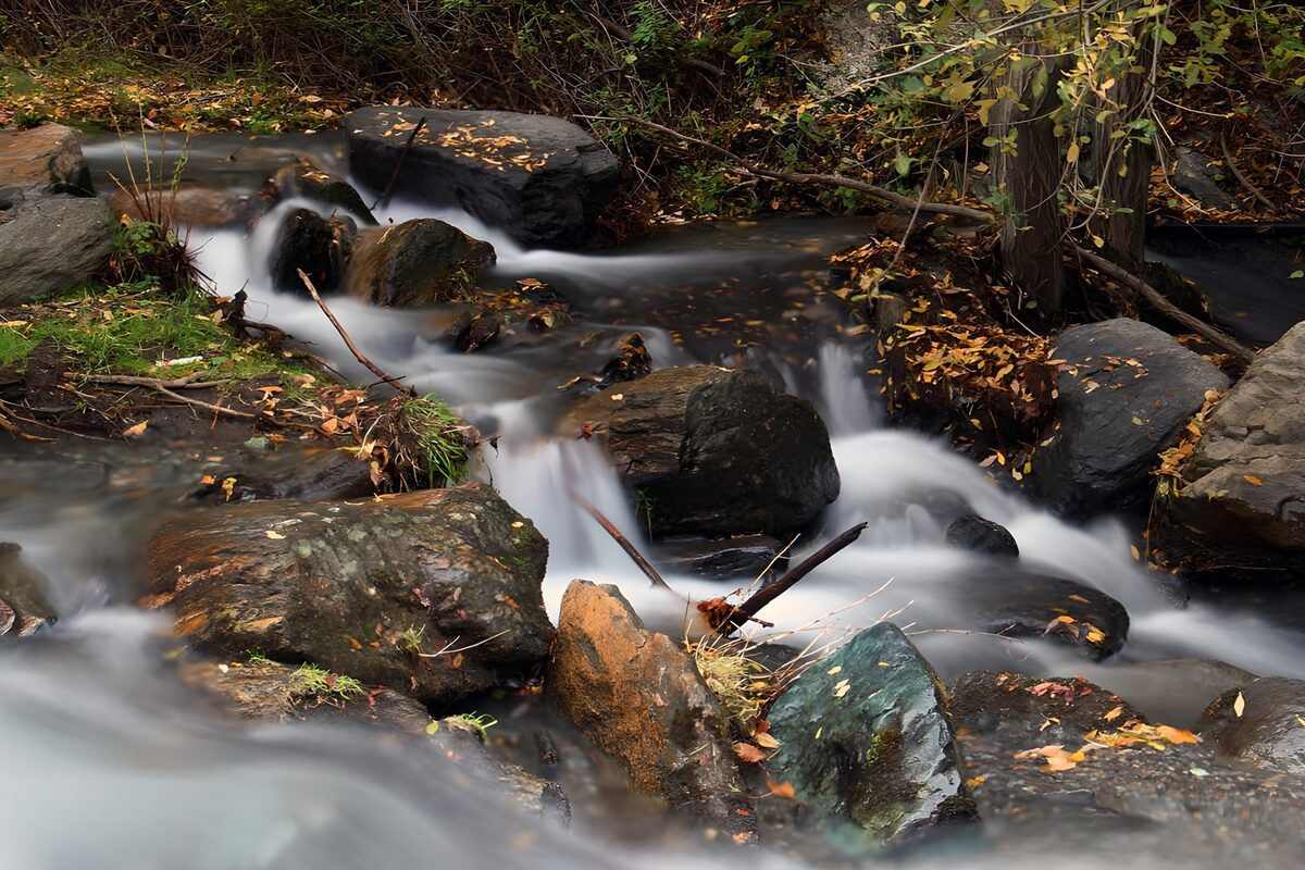 Herbstlicher Waldbach zwischen Felsen