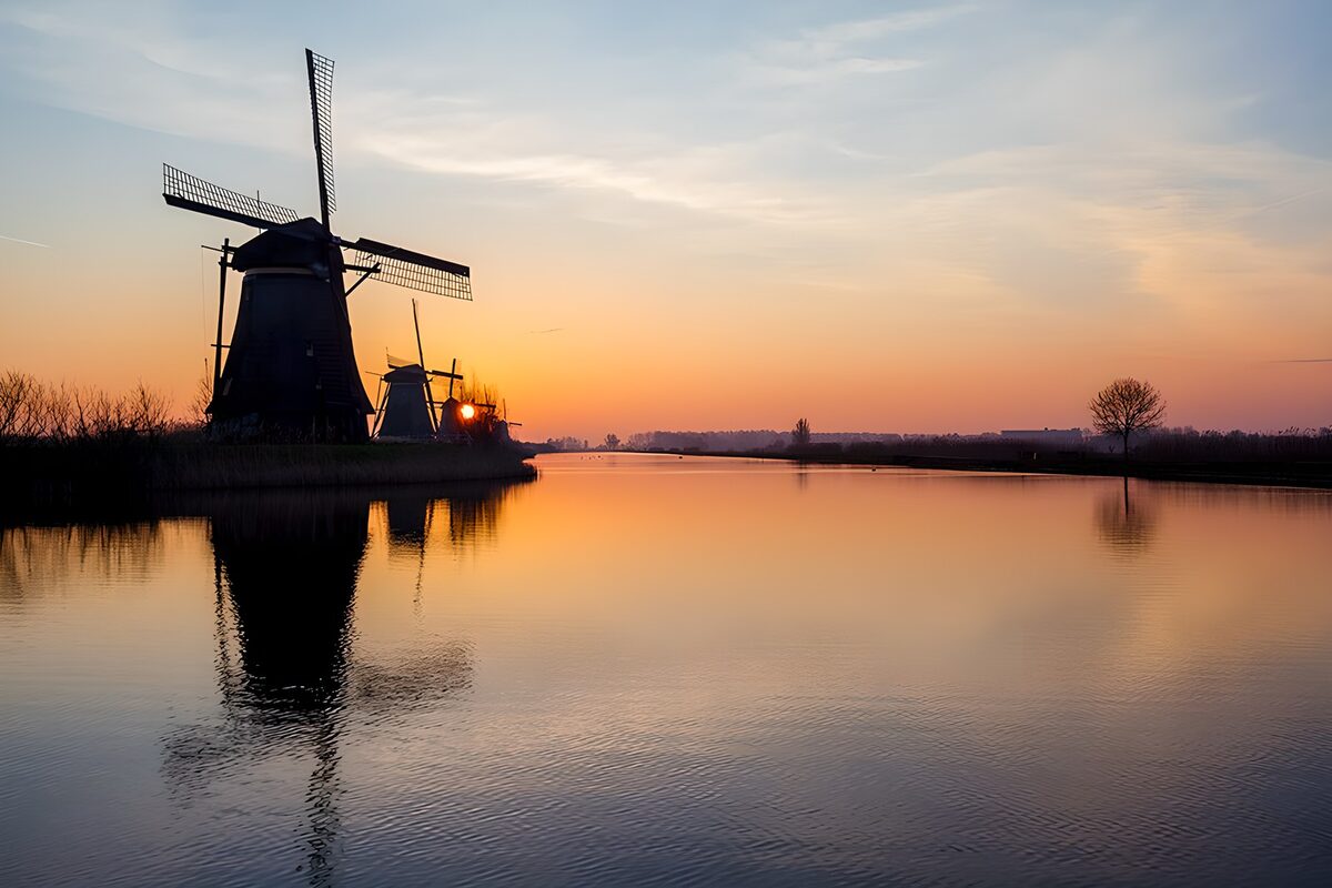 Windmühlen am Wasser im Abendlicht