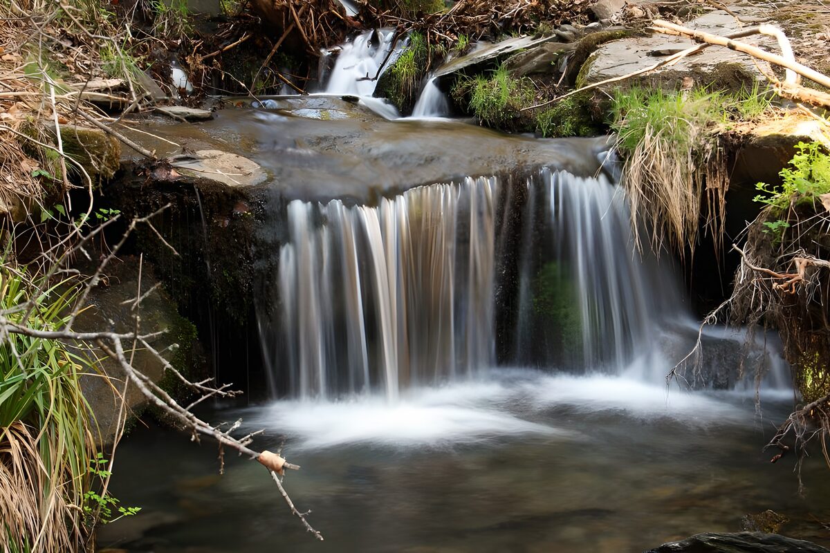 Kleiner Wasserfall auf dunklen Felsstufen