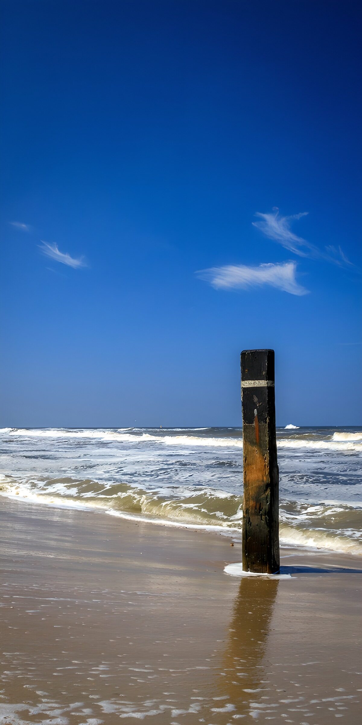 Holzpfosten am Strand bei Wellengang