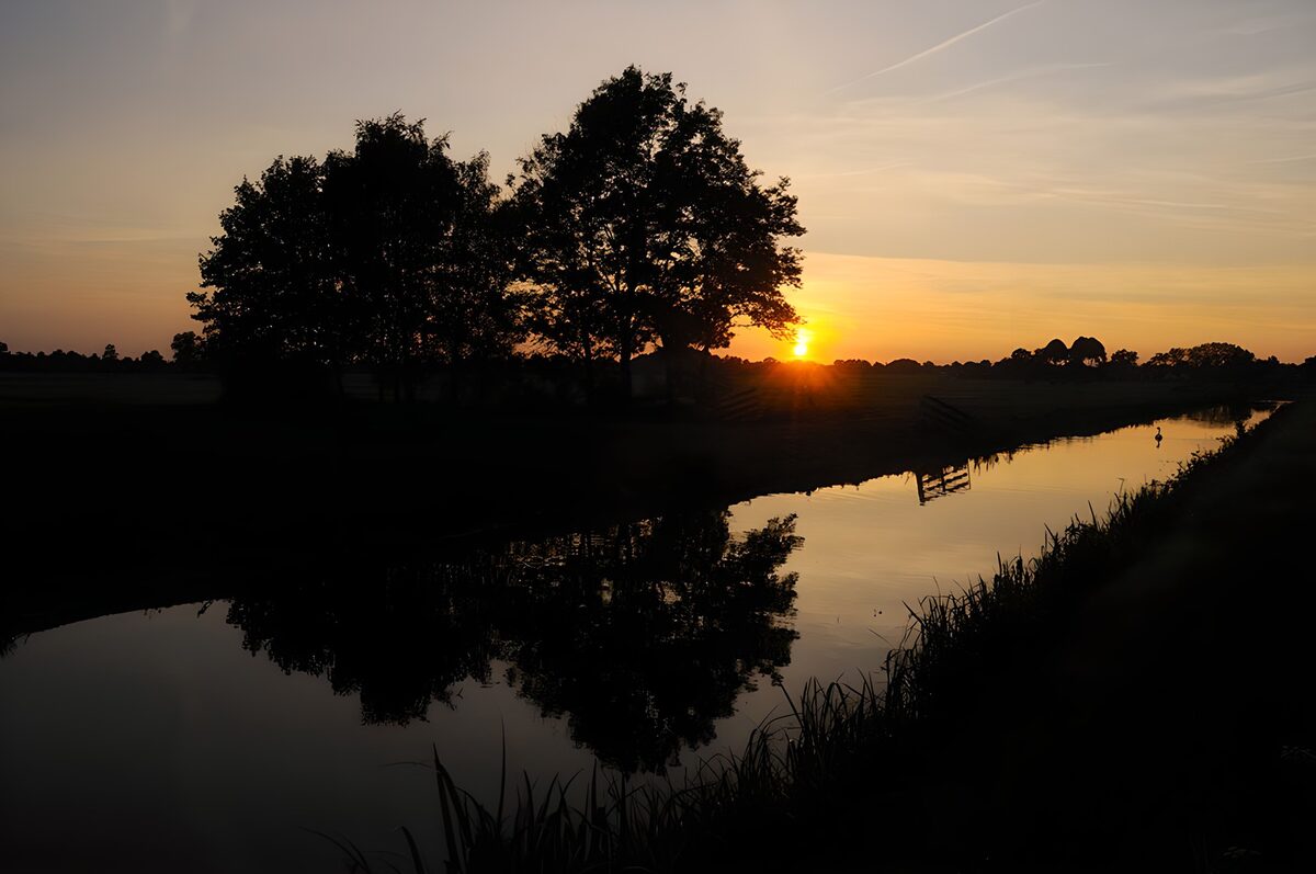 Sonnenuntergang am schmalen Wasserlauf