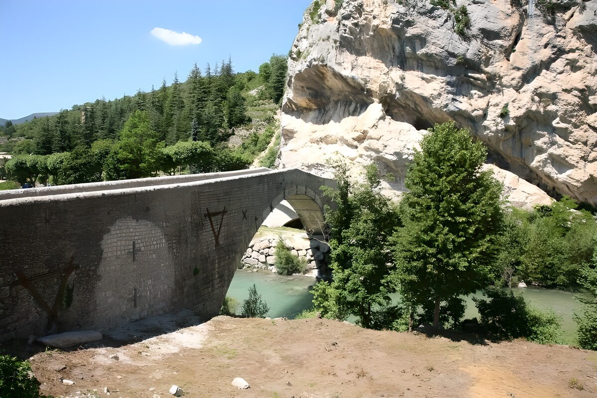 Steinbrücke vor sonnenheller Felswand