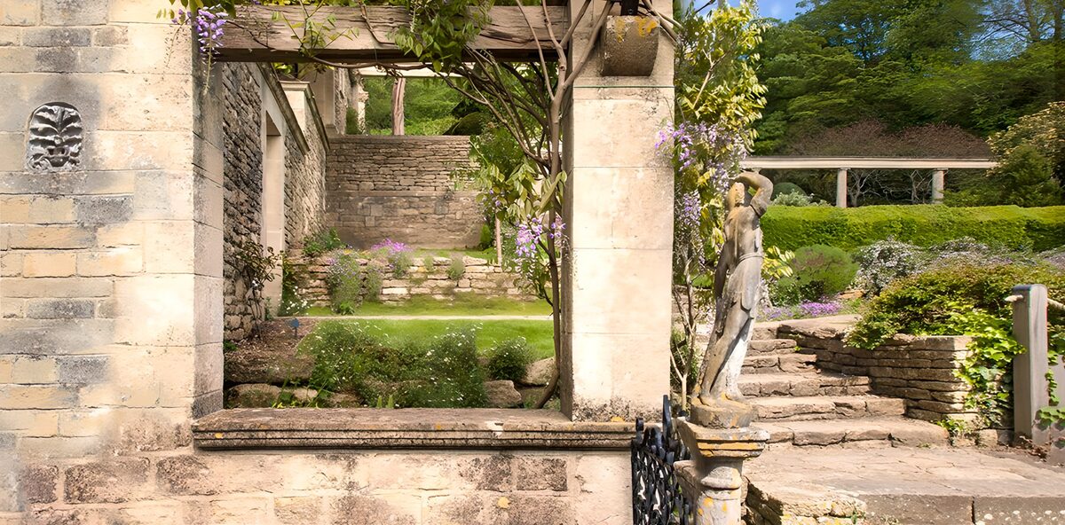 Garten mit Blauregen und Steinfigur
