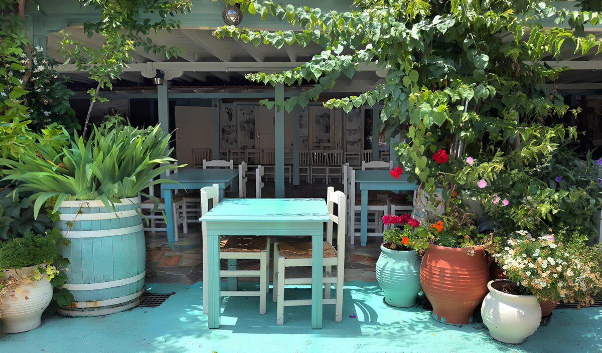 Türkise Tische auf blühender Caféterrasse