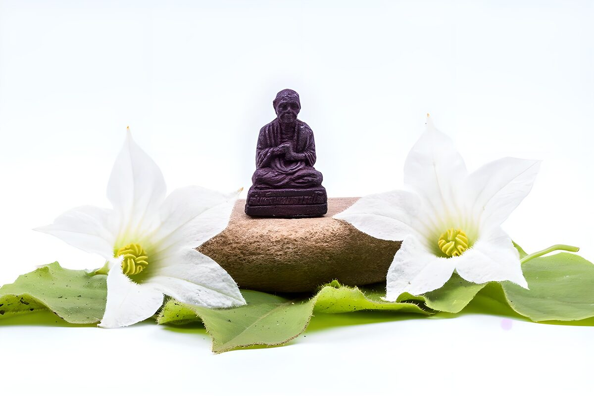Meditationsfigur mit zwei weißen Blüten