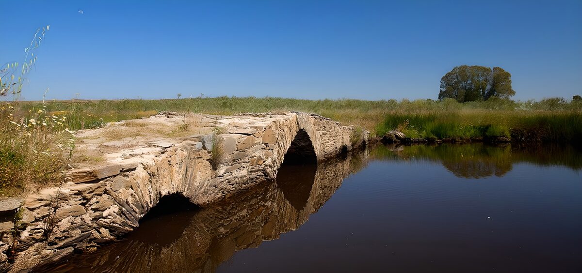 Alte Steinbrücke über ruhigem Wasser