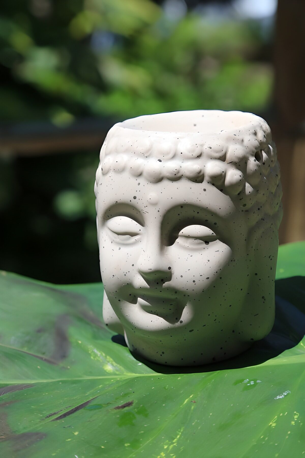 Weißer Buddhakopf auf grünem Blatt