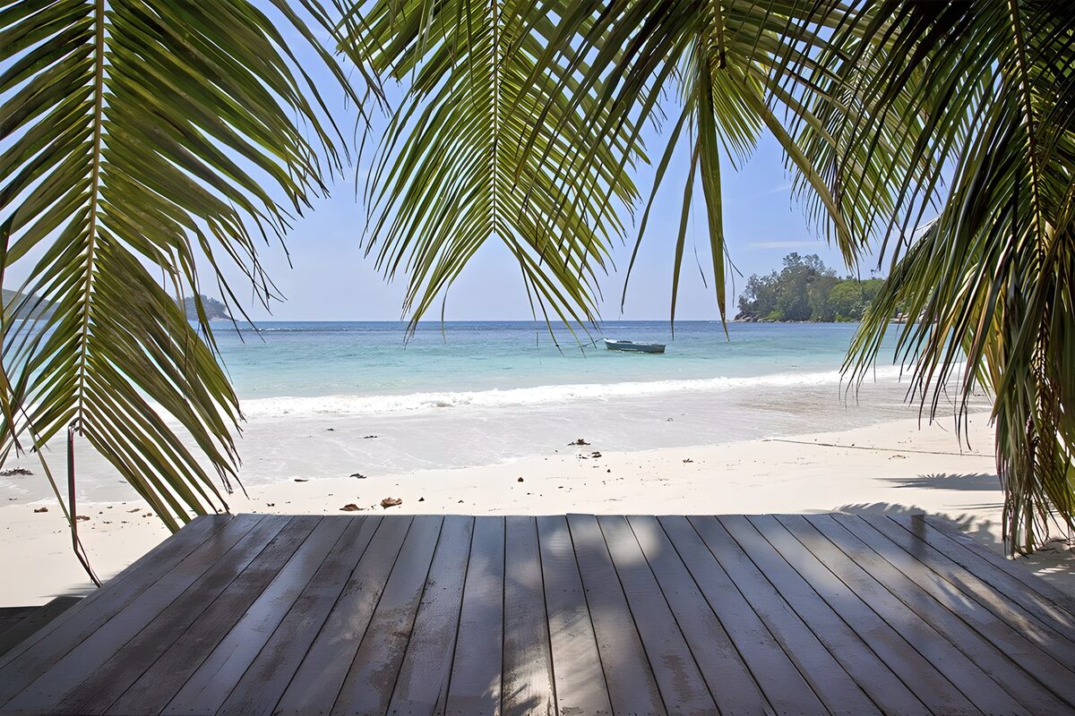 Holzdeck mit Blick auf den Palmenstrand