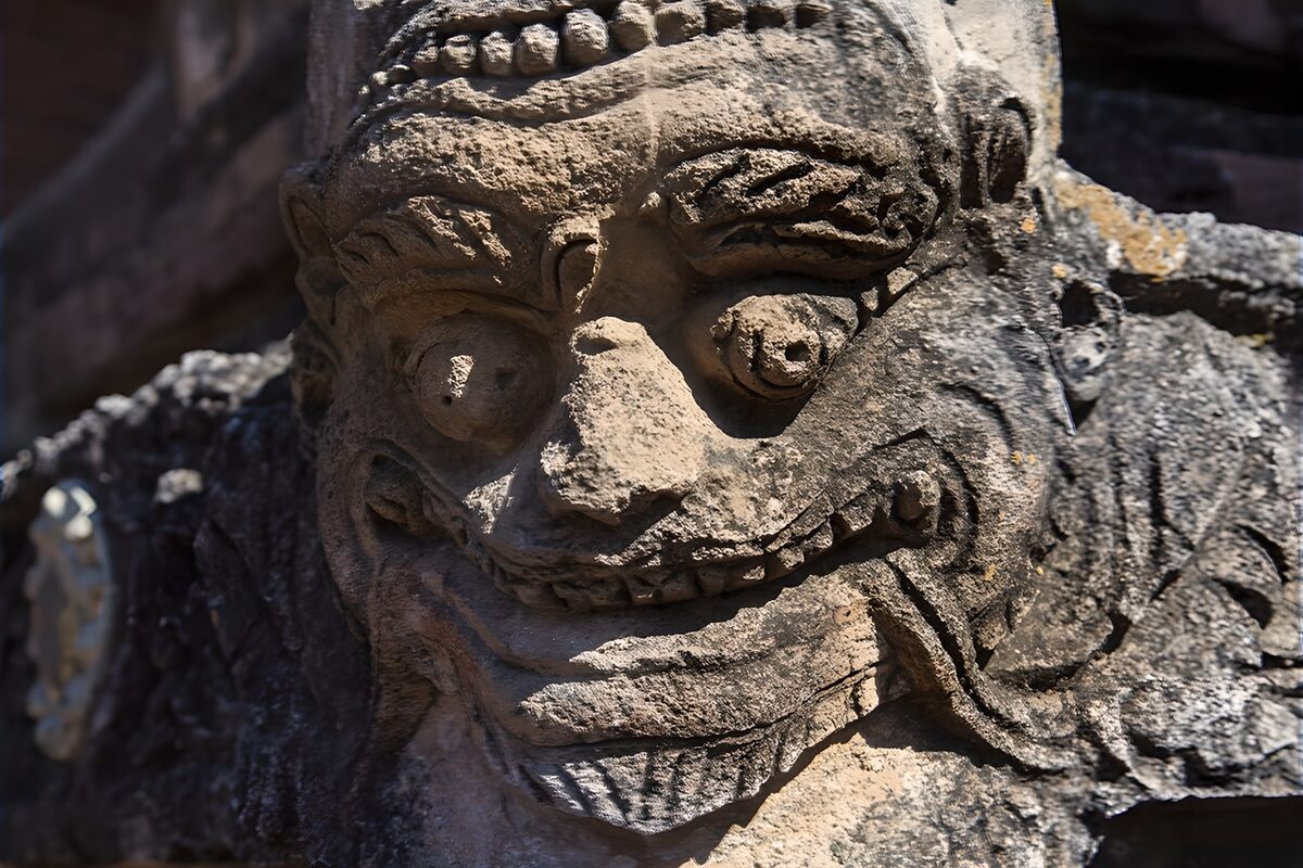 Verwitterte Steinmaske im Sonnenlicht