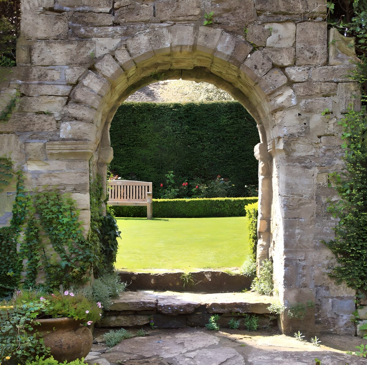 Alter Steinbogen zum sonnigen Garten