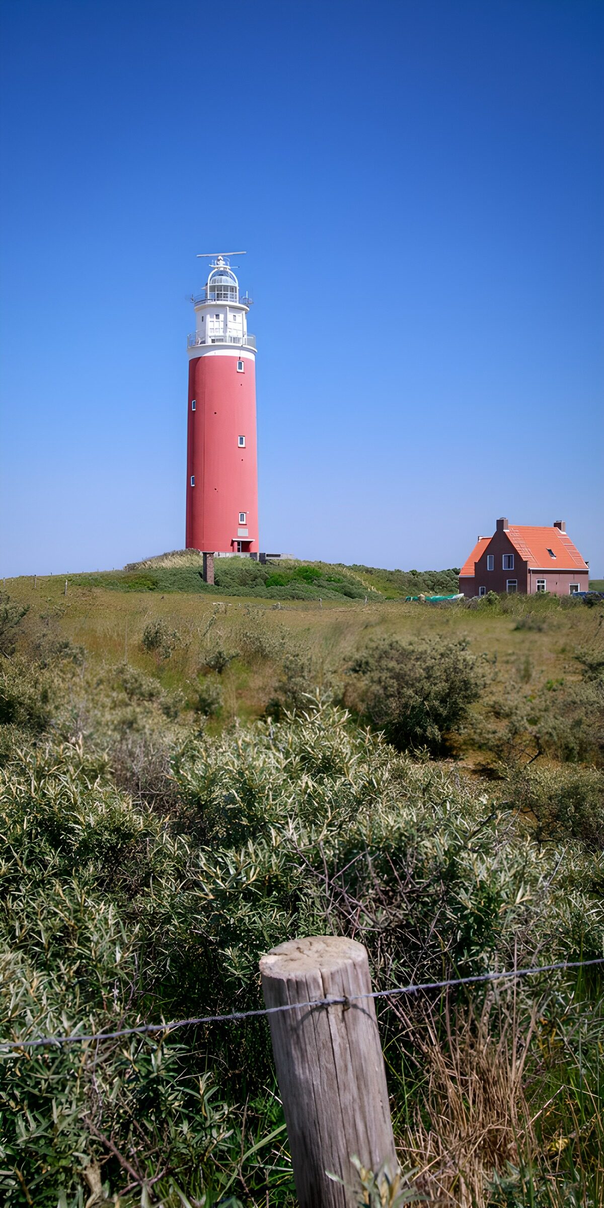 Rot-weißer Leuchtturm über den Dünen