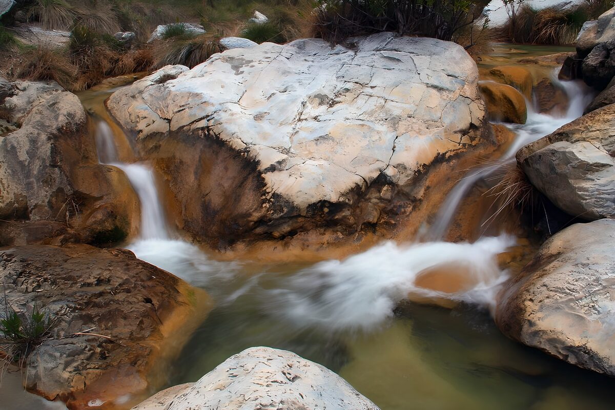 Heller Felsblock zwischen Wasserfällen