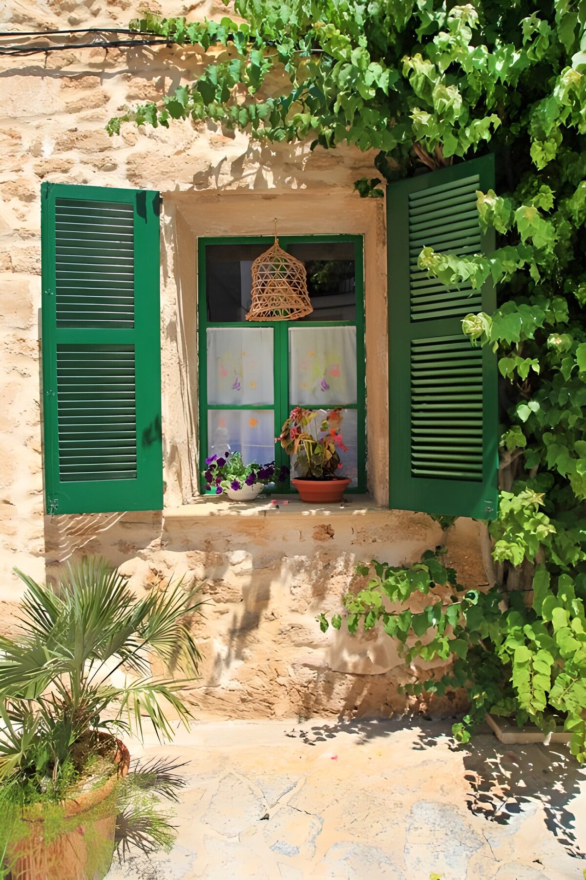 Grüne Fensterläden an warmer Steinwand