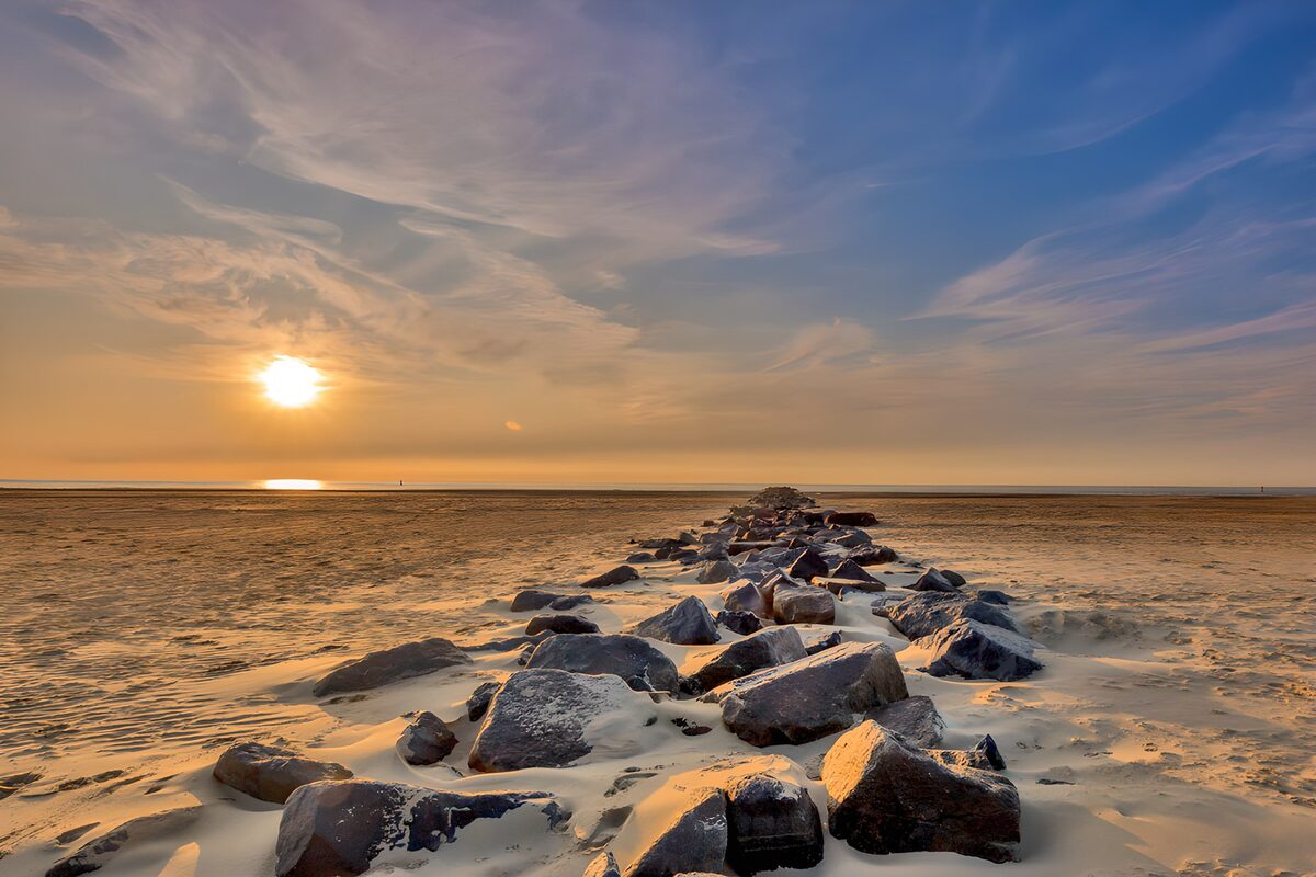 Sonnenuntergang am Strand mit Felsen