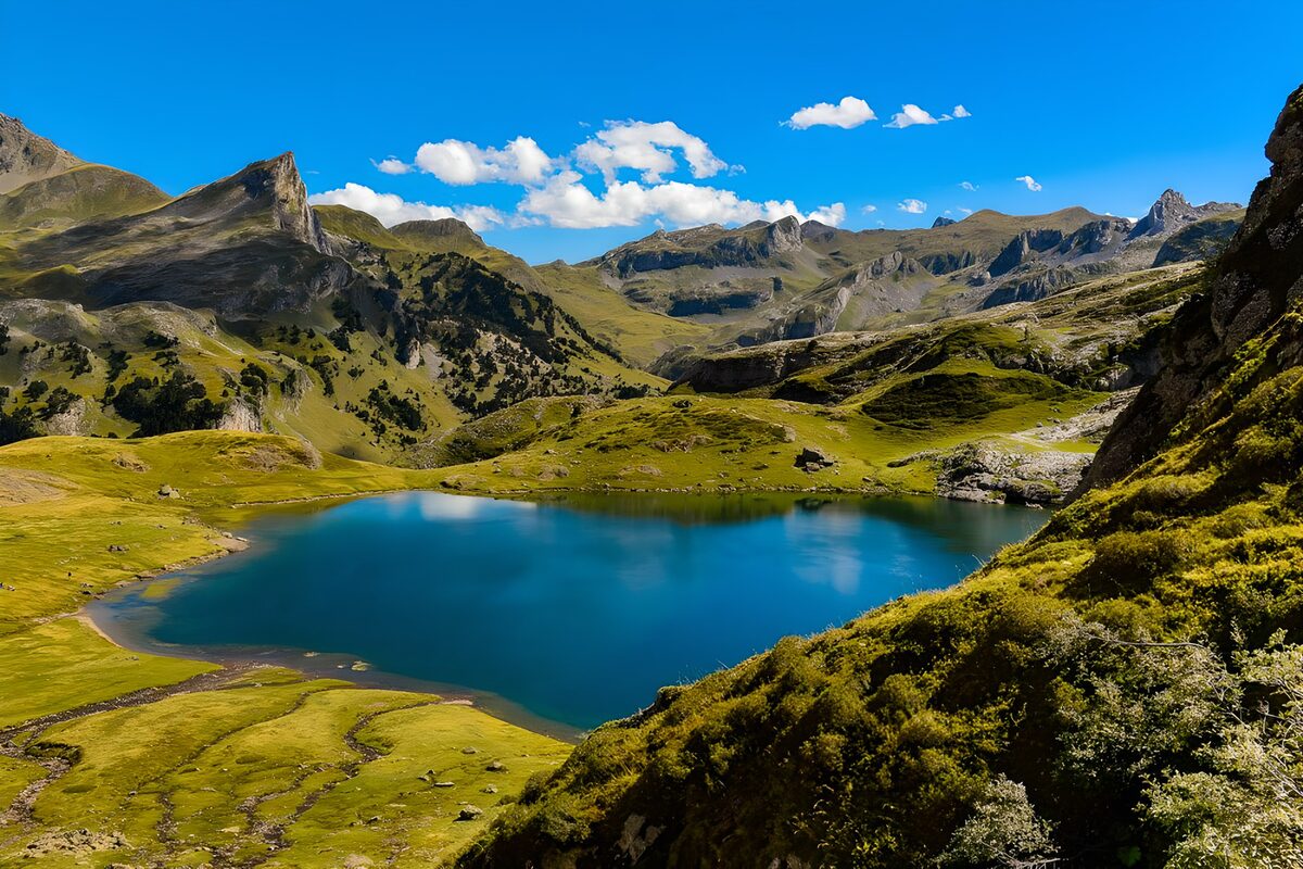 Tiefblauer Bergsee zwischen grünen Hängen