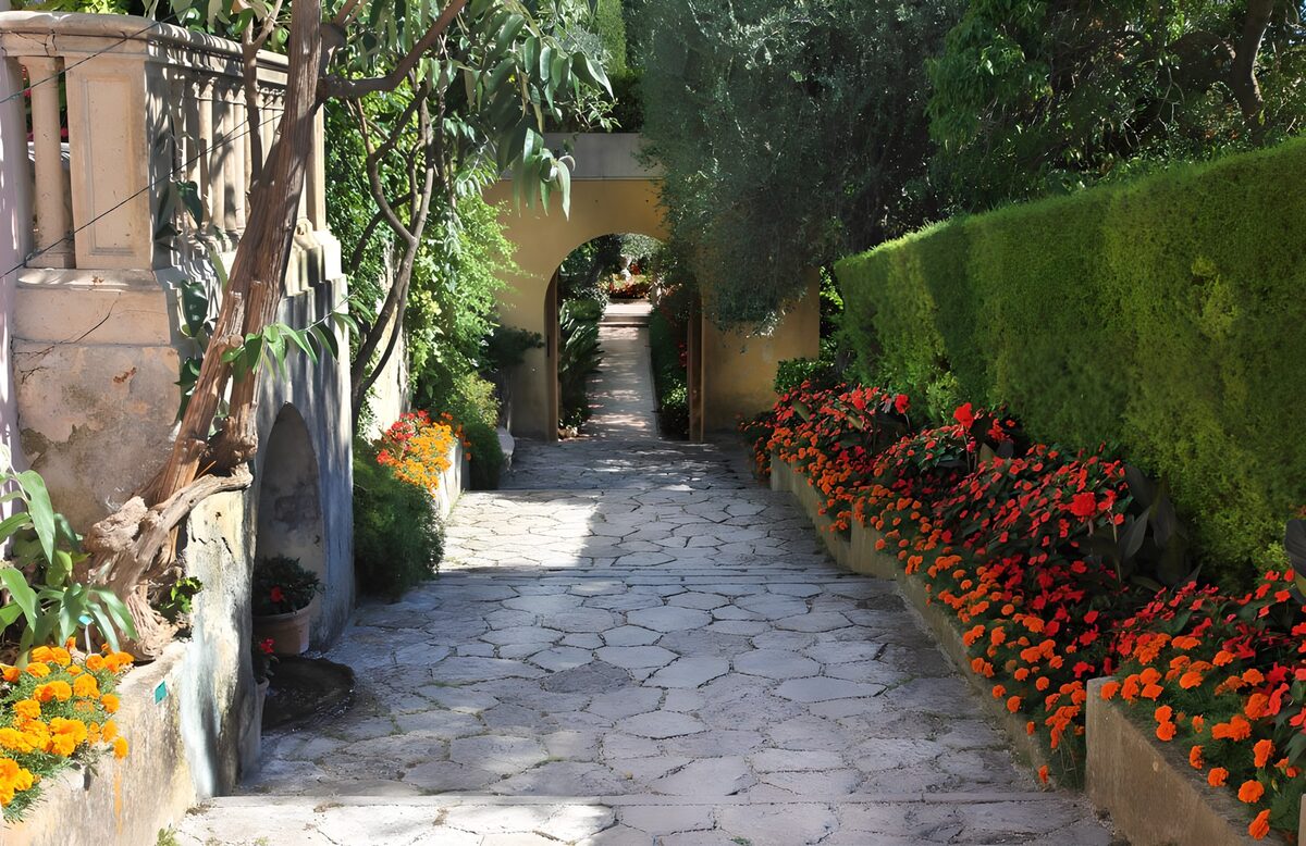 Steinweg mit Blüten und Torbogen